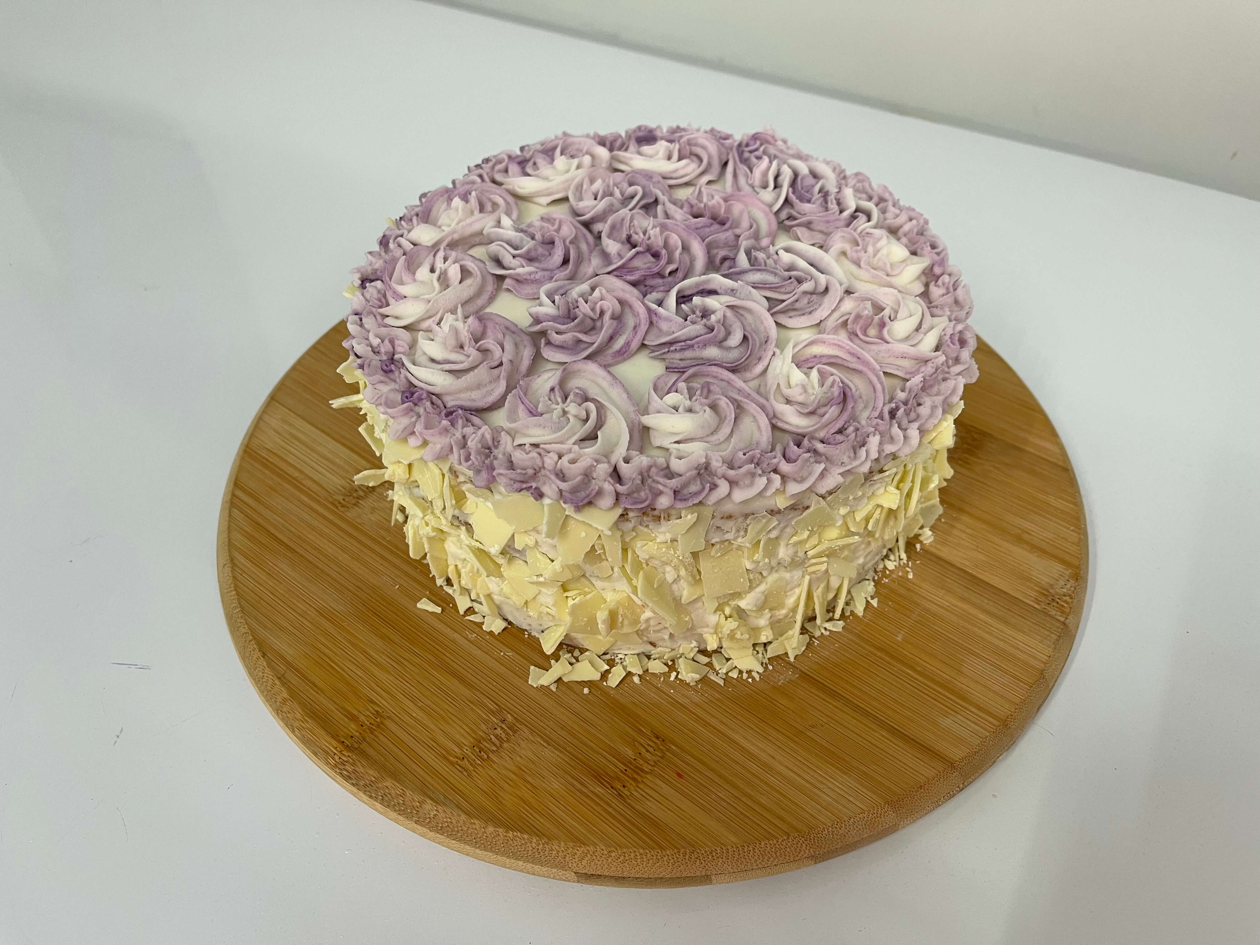 White chocolate and blueberry layer cake with white chocolate buttercream and white chocolate shavings.