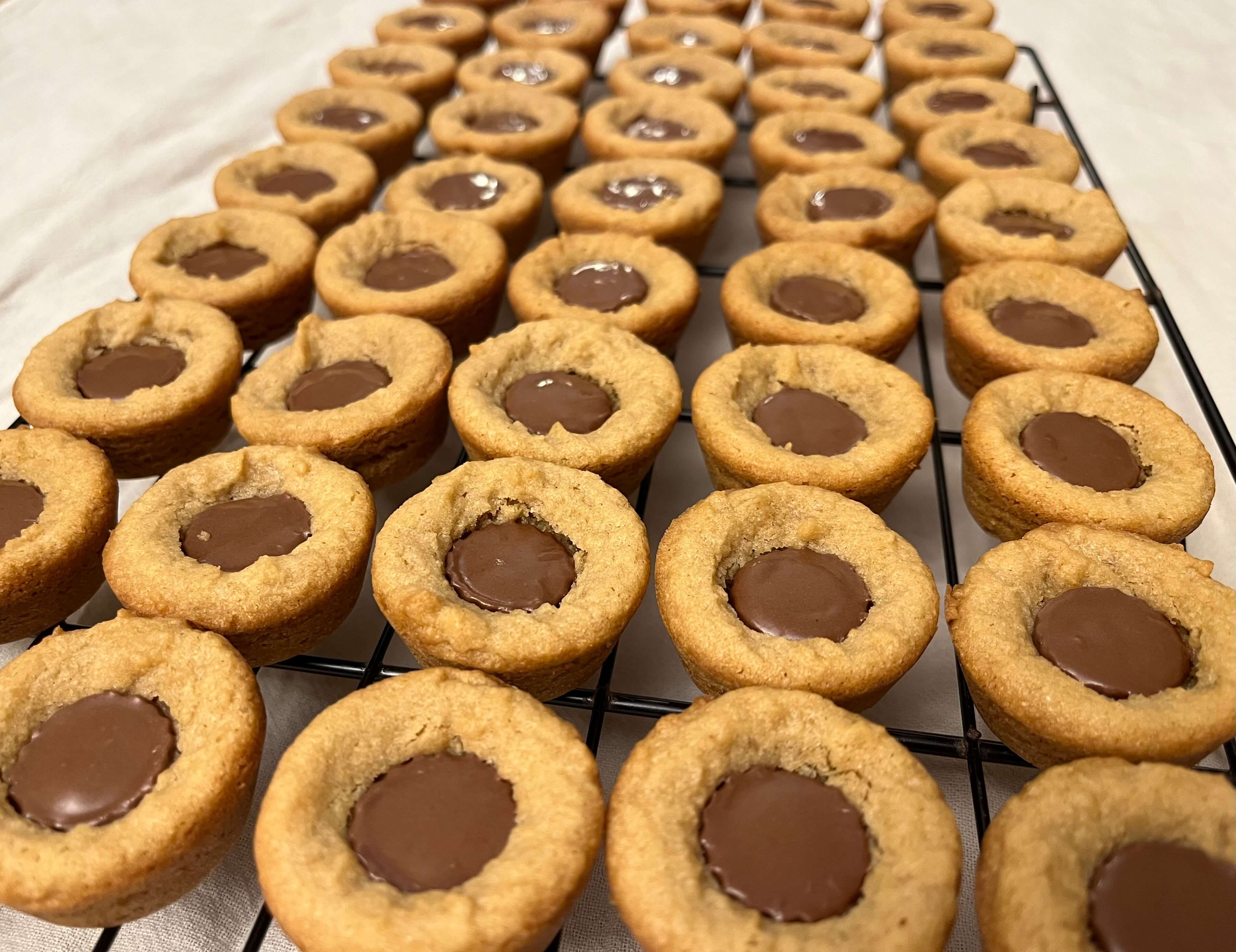 Mini peanut butter cups pressed into freshly baked peanut butter cookies.