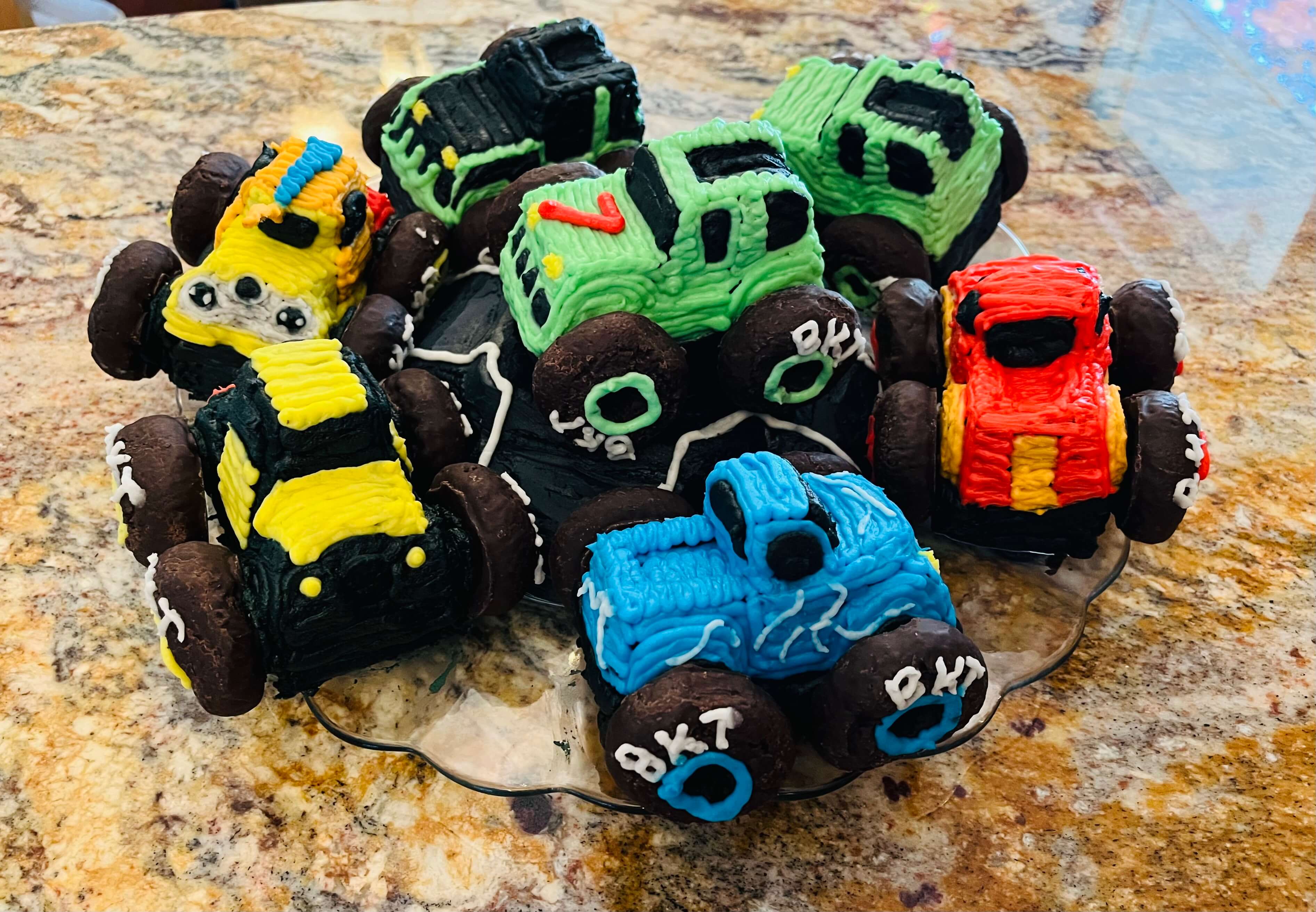 Chocolate monster truck cupcakes with vanilla frosting.